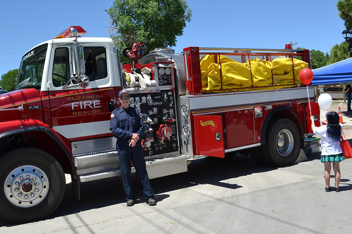 A firefighter in front of a fire apparatus at Elizabash