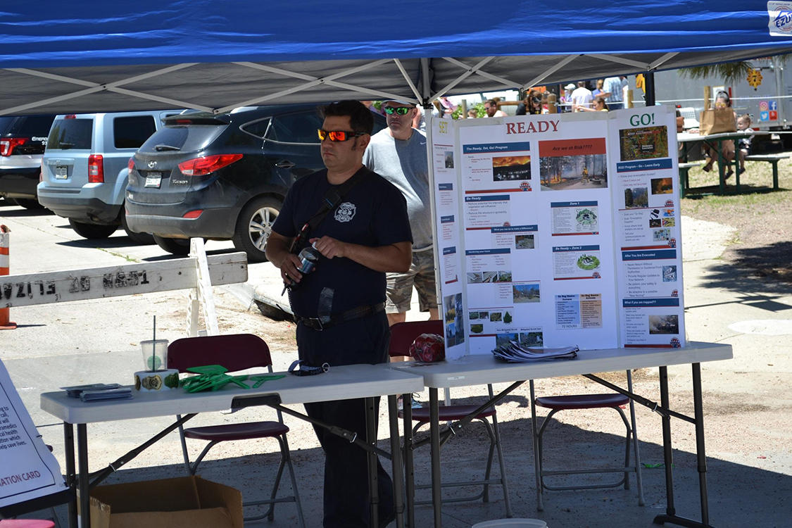 A firefighter at a safety information table at Elizabash