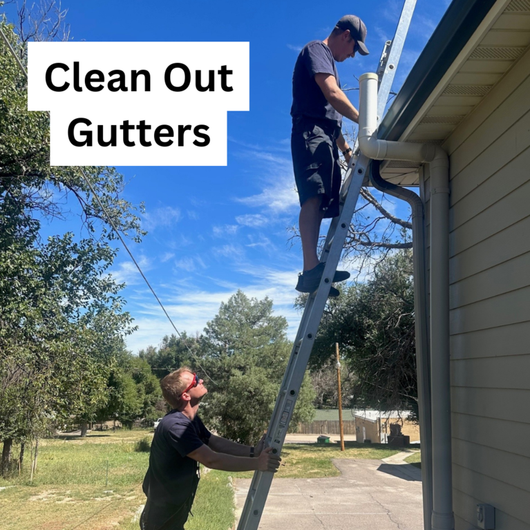 A firefighter on a ladder cleaning out gutters and a firefighter holding the base of the ladder with the caption "Clean Out Gutters"