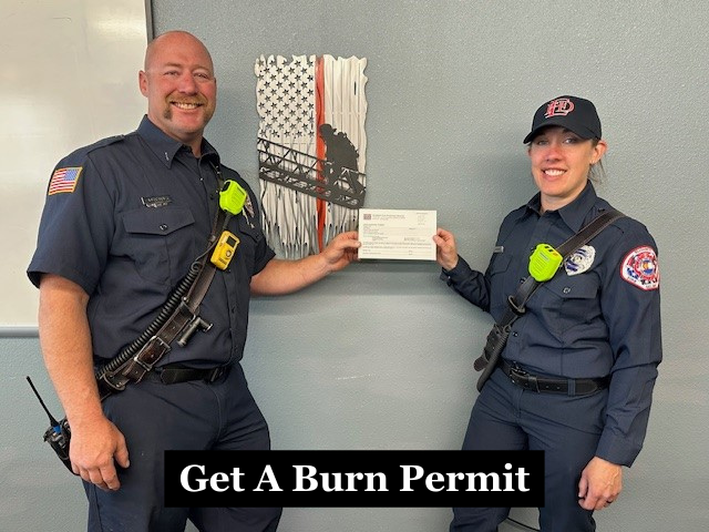 Firefighters holding a burn permit with the caption "Get A Burn Permit"
