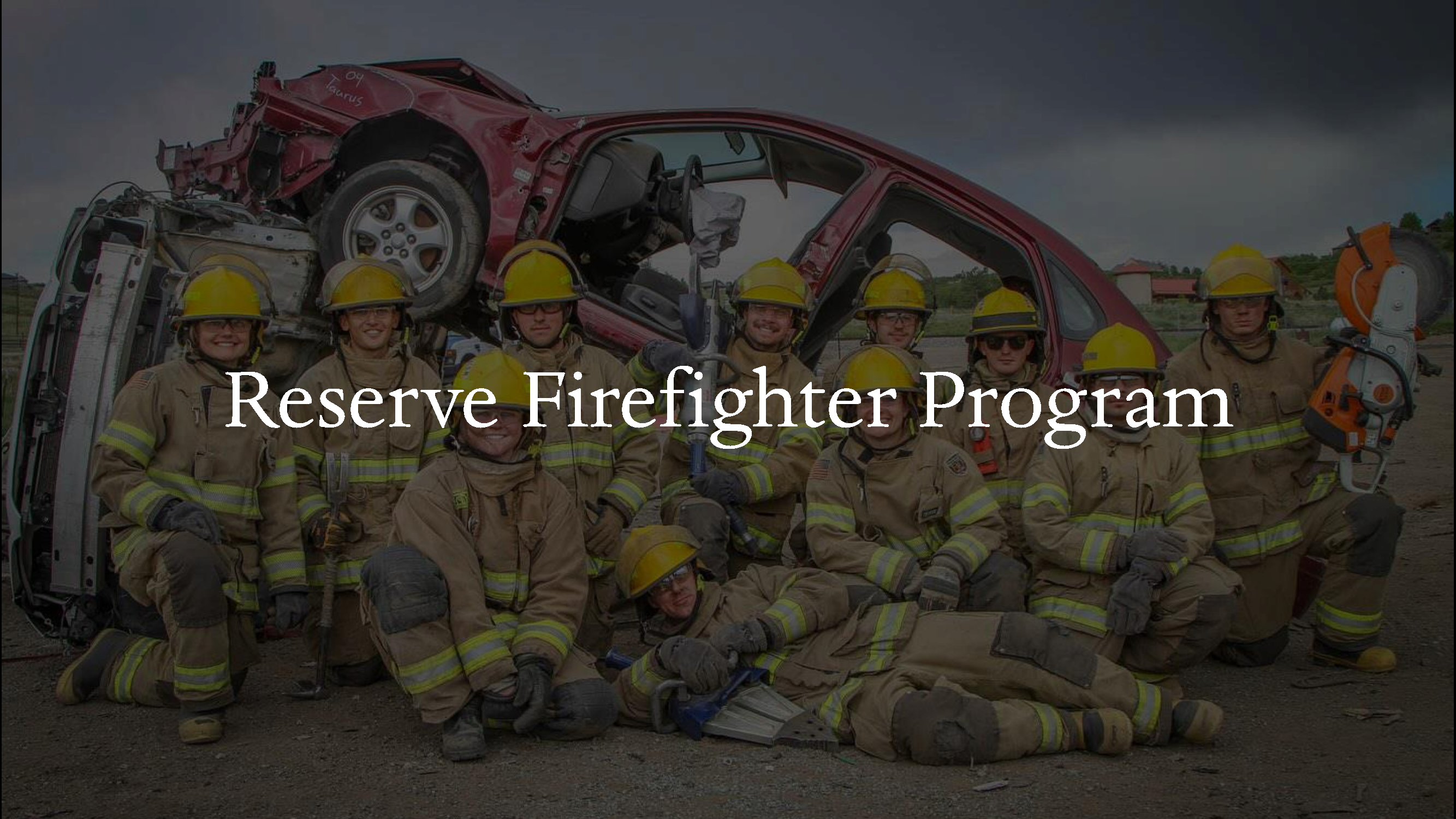 Reserve firefighters posing in front of a car during an extrication training