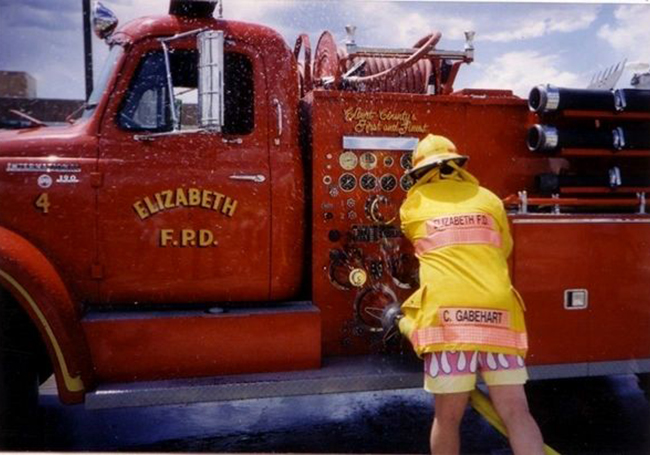 A firefighter standing in front of a fire vehicle