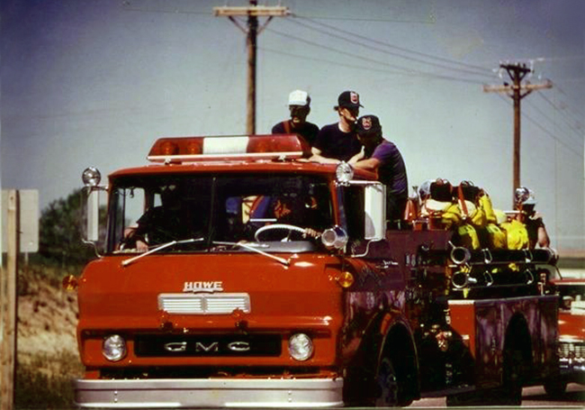 Firefighters riding in a fire vehicle