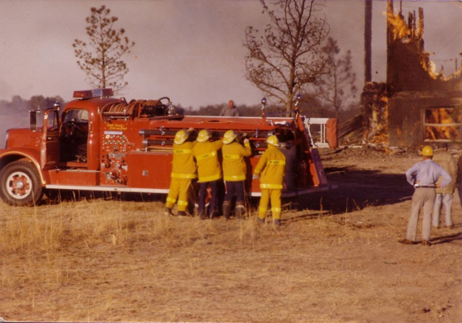 Firefighters in front of a fire vehicle on scene of a fire