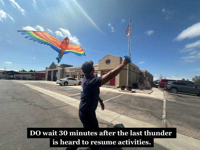 A firefighter flying a kite with the caption "DO wait 30 minutes after the last thunder is heard to resume activities."