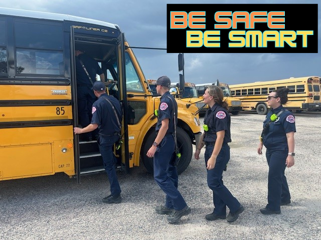 Firefighters boarding a school bus with the caption "Be Safe Be Smart"