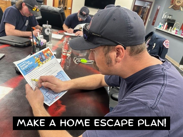 Firefighter working on a home escape plan with the caption "Make a Home Escape Plan!"