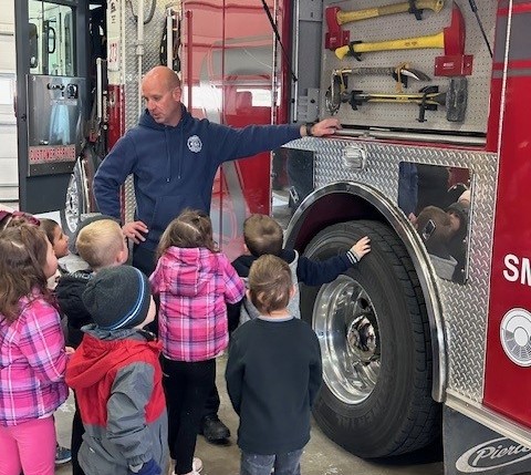 Firefighters showing kids the fire engine