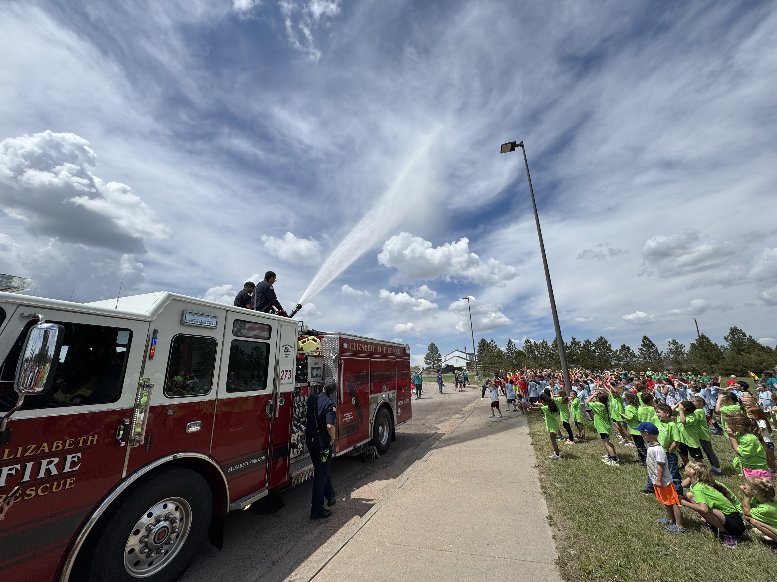 Crews spraying water on kids during a field day