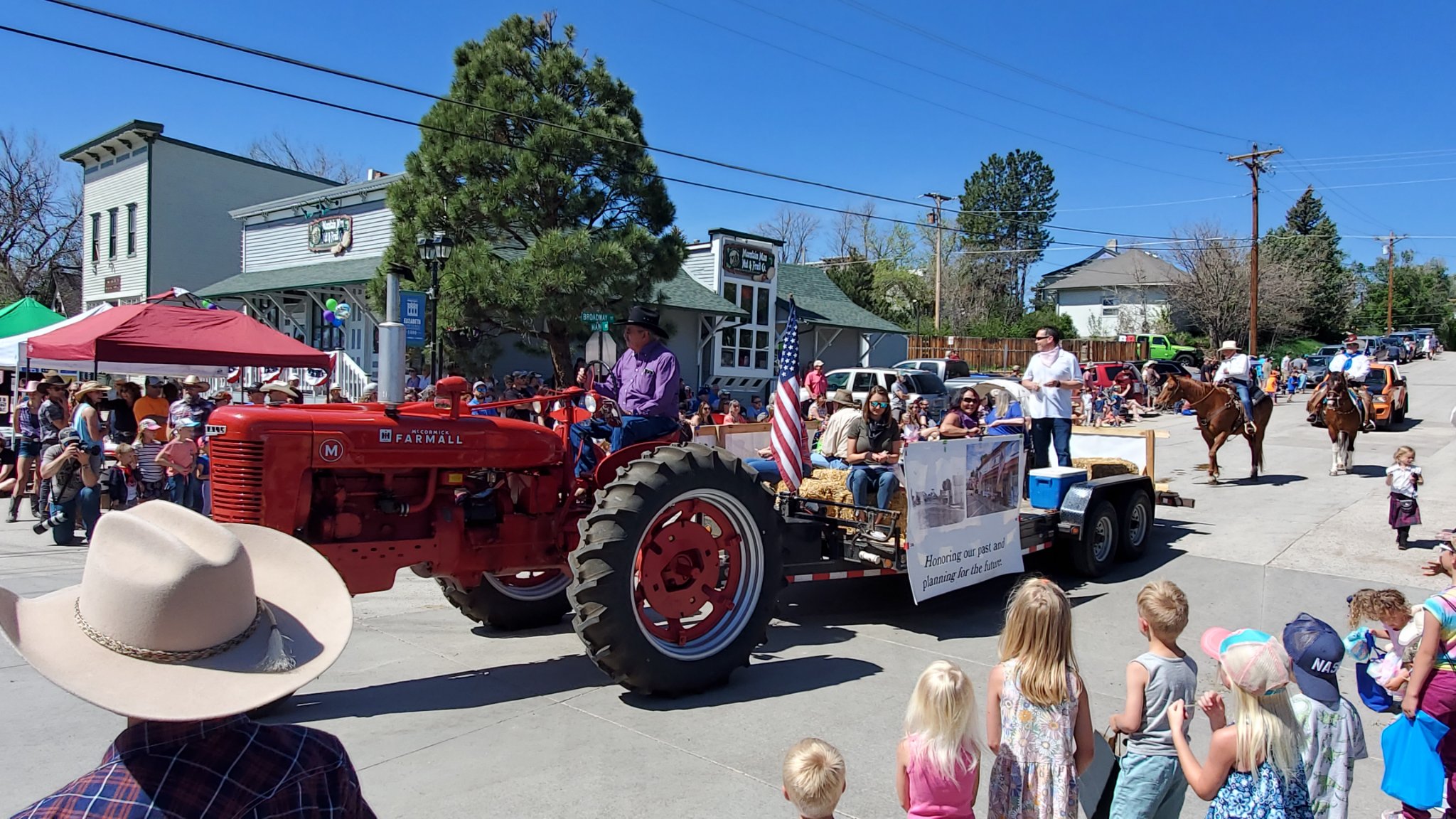 People riding behind a tractor in a parade