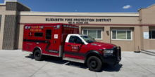 A medic ambulance parked in front of a fire station