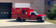A medic ambulance parked in front of a fire station
