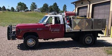A brush truck parked outside of a station