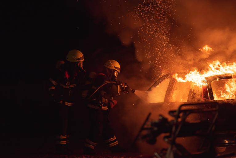 Firefighters putting out a car fire